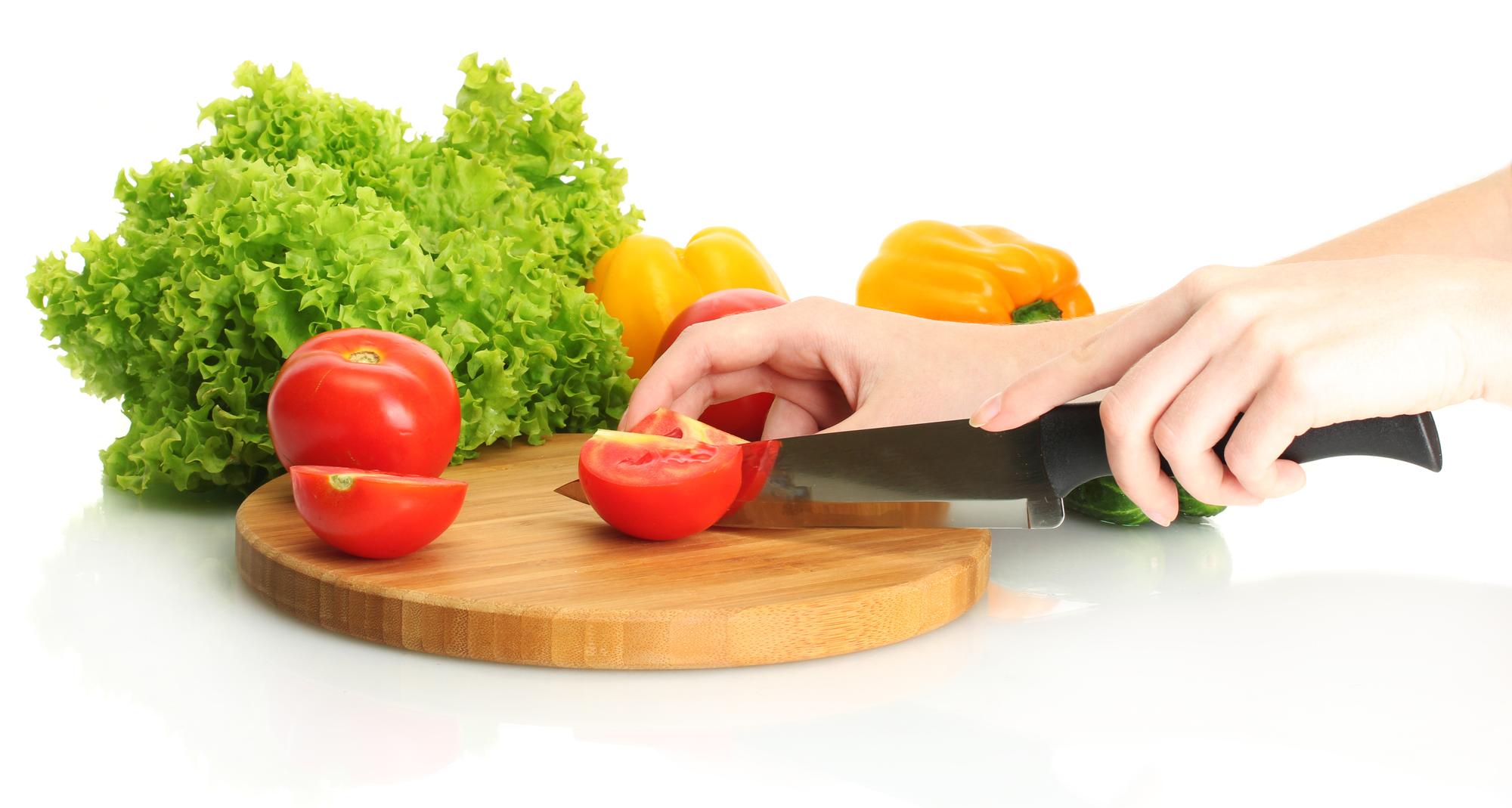 Close-up of hands slicing vegetables with careful technique